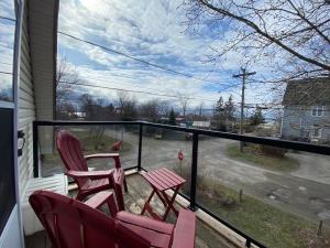 duas cadeiras num alpendre com vista para uma rua em Private Room- Shediac Beach House em Shediac