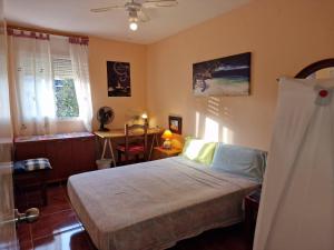 1 dormitorio con cama, escritorio y ventana en Fuengirola Rooms Boliches Beach, en Fuengirola