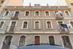 Un edificio con ventanas y un coche delante. en Apartment Pontevedra 20m from the beach, en Barcelona