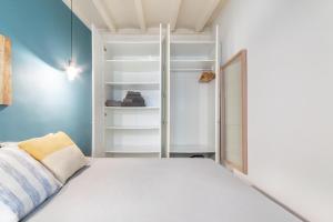 1 dormitorio con cama blanca y armario en Apartment Pontevedra 20m from the beach, en Barcelona