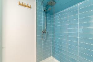 y baño con ducha de azulejos azules. en Apartment Pontevedra 20m from the beach, en Barcelona 18 fotos más