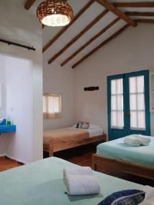 Zimmer mit 2 Betten und einem Kronleuchter in der Unterkunft Hotel Casa Del Viento Zapatoca in Zapatoca