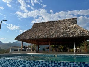 Cabaña con piscina y techo de paja en Rancho Agua Fria en Jucuarán