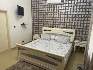 1 dormitorio con 1 cama en una habitación con pared en Tarablue appart, En plein centre-ville, Agréable & spacieux, en Libreville