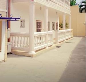 un edificio blanco con columnas blancas y balcón en Tarablue appart, En plein centre-ville, Agréable & spacieux, en Libreville