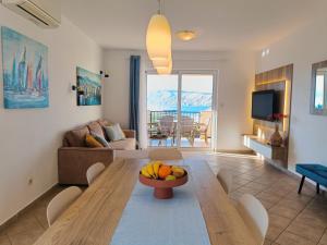 a living room with a table with a bowl of fruit on it at Haus Mit Meerblick in Lopar