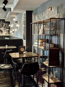 ein Restaurant mit Tischen, Stühlen und Regalen mit Gläsern in der Unterkunft Boutique Hotel Sonne Seuzach in Winterthur