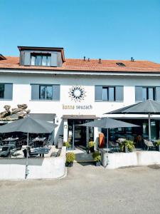 un bâtiment avec des tables et des parasols devant lui dans l'établissement Boutique Hotel Sonne Seuzach, à Winterthour