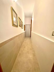 un corridoio con dipinti alle pareti e pavimento piastrellato di Il girasole a Tuglie