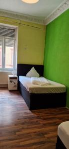 ein Schlafzimmer mit einem Bett mit einer grünen Wand in der Unterkunft WOHNUNG IN KAISERSLAUTERN in Kaiserslautern + 13 Fotos
