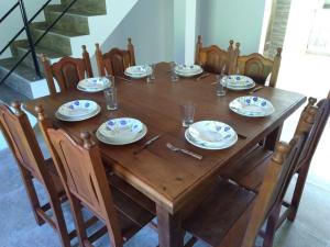 einem Holztisch mit Stühlen und Tellern darauf in der Unterkunft Las Tranqueritas in Trapiche
