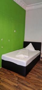 un letto in una camera con parete verde di WOHNUNG IN KAISERSLAUTERN a Kaiserslautern