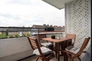 a balcony with a wooden table and chairs on a roof at Ruhiges und modernes Zuhause in Münster