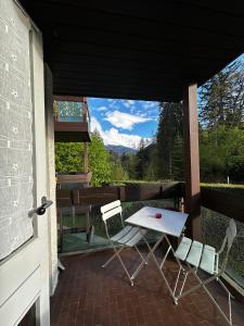 une terrasse couverte avec une table et des chaises. dans l'établissement Castel de Roches, à Saint-Gervais-les-Bains