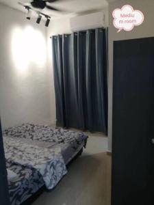 ein Schlafzimmer mit einem Bett und einem blauen Vorhang in der Unterkunft Simpang Ampat QQ in Simpang Ampat
