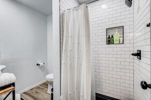 a white shower curtain in a bathroom with a toilet at Charming Getaway in Stillwater in Stillwater