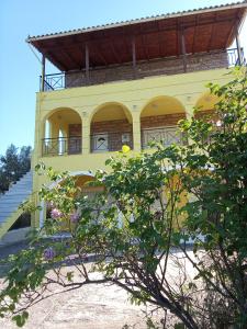 a yellow building with a balcony on top of it at VILLA S&A MEDITATION in Chalkida