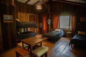 艾索貝比歐的住宿－Lodge Paraíso，客厅配有双层床和桌子