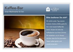 een kopje koffie op een tafel met koffiebonen bij Auszeit Borkum in Borkum