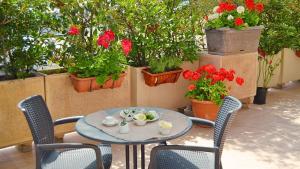 a table and chairs with flowers on a patio at Manfredi Apartments in Torre Annunziata
