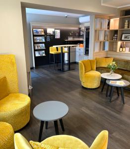 uma sala de espera com cadeiras e mesas amarelas em Hotel Rose em Rüdesheim am Rhein