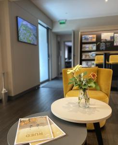 ein Wohnzimmer mit einer Blumenvase auf dem Tisch in der Unterkunft Hotel Rose in Rüdesheim am Rhein