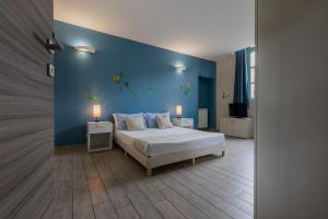1 dormitorio con cama y pared azul en Housing Giulia, en Turín