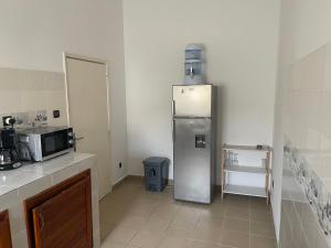 a kitchen with a stainless steel refrigerator in the corner at Tarablue appart, En plein centre-ville, Agréable & spacieux in Libreville