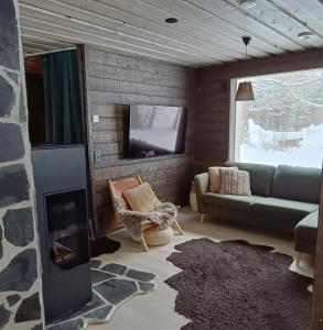 a living room with a couch and a tv at Lapland Hygge in Rovaniemi