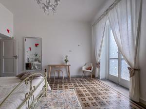 a bedroom with a bed and a table and a window at Franci House in Sant'Agnello