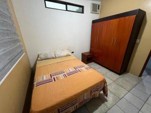 - une chambre avec un lit et une armoire en bois dans l'établissement surf house, à Puerto Baquerizo Moreno