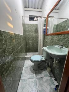 y baño con aseo y lavamanos. en surf house, en Puerto Baquerizo Moreno