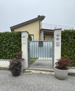 ein Haus mit einem Tor und zwei Topfpflanzen in der Unterkunft B&B Rivanazzano Tavernetta tra vino e terme in Rivanazzano