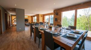 a dining room with a long wooden table and chairs at Les Chalets de La Marcairie in Metzeral