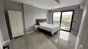 Un dormitorio con una cama y una ventana grande. en Greenplain Luxury, en Trabzon