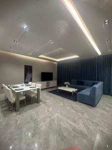 uma sala de estar com um sofá azul e uma mesa em Jamal Royal Apartments em Medina