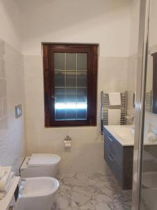 a bathroom with a toilet and a sink and a window at rooms speedy vicino aeroporto e fiera di roma in Fiumicino