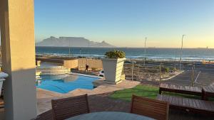 a balcony with a view of the beach and the ocean at Oceansnest Guest House in Bloubergstrand