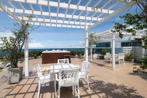 um pátio com cadeiras brancas, uma mesa e uma pérgola em Luxury apartment, sector morros, vista y salida al mar edificio Sunshine em Cartagena das Índias