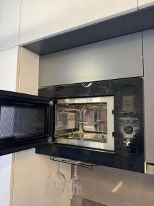 a toaster oven in a kitchen with two wine glasses at The Mauve by DiMerro 38th Floor in New Delhi