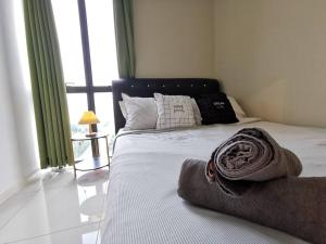 ein Schlafzimmer mit einem Bett mit einer Decke darauf in der Unterkunft F 2 Rooms PJ Near SunwayPyramid 100MbpsWifi 中文房东 in Petaling Jaya