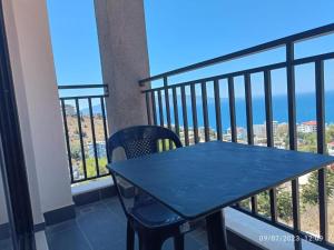 a table on a balcony with a view of the ocean at Davids Apartments in Sarandë