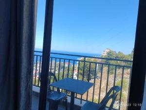 a balcony with a table and chairs and a view of the ocean at Davids Apartments in Sarandë