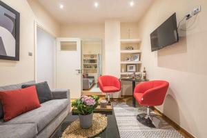 sala de estar con sofá y 2 sillas rojas en Ermis exclusive apt in Kolonaki, en Atenas