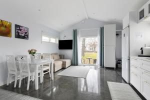 eine Küche und ein Wohnzimmer mit einem Tisch und einem Sofa in der Unterkunft Park House Gävle - a modern renovated house in the park - 5A in Gävle
