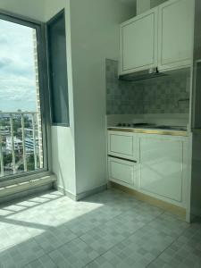 una cucina con armadi bianchi e una grande finestra di Centric 2bedrooms and 2 bathrooms suite a Bangkok