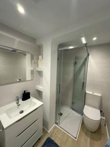 Un baño con ducha, inodoro y lavabo. en Arritokieta, en Zumaia