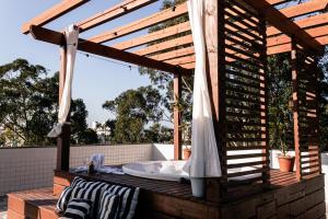 a wooden pergola with a bath tub on a deck at Mar e Mar Florianópolis in Florianópolis