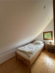Domek Bajka في فودميني: غرفة نوم مع سرير في العلية