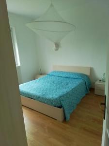 a bedroom with a bed with a blue comforter at P&P Bergamo Apartment in Bergamo +10 photos